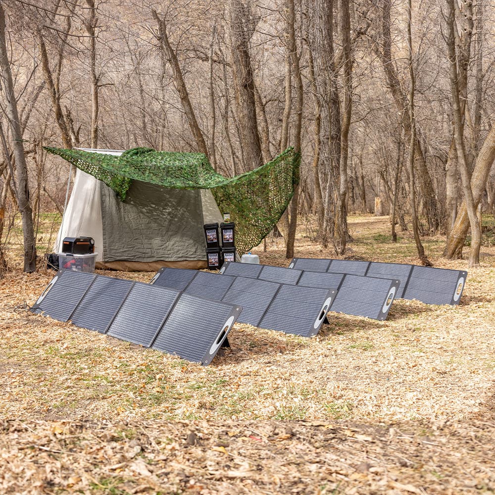 Four Grid Doctor 200W Solar Panels placed in a row on a grassy surface, fully extended to capture sunlight, demonstrating a versatile outdoor solar power setup.