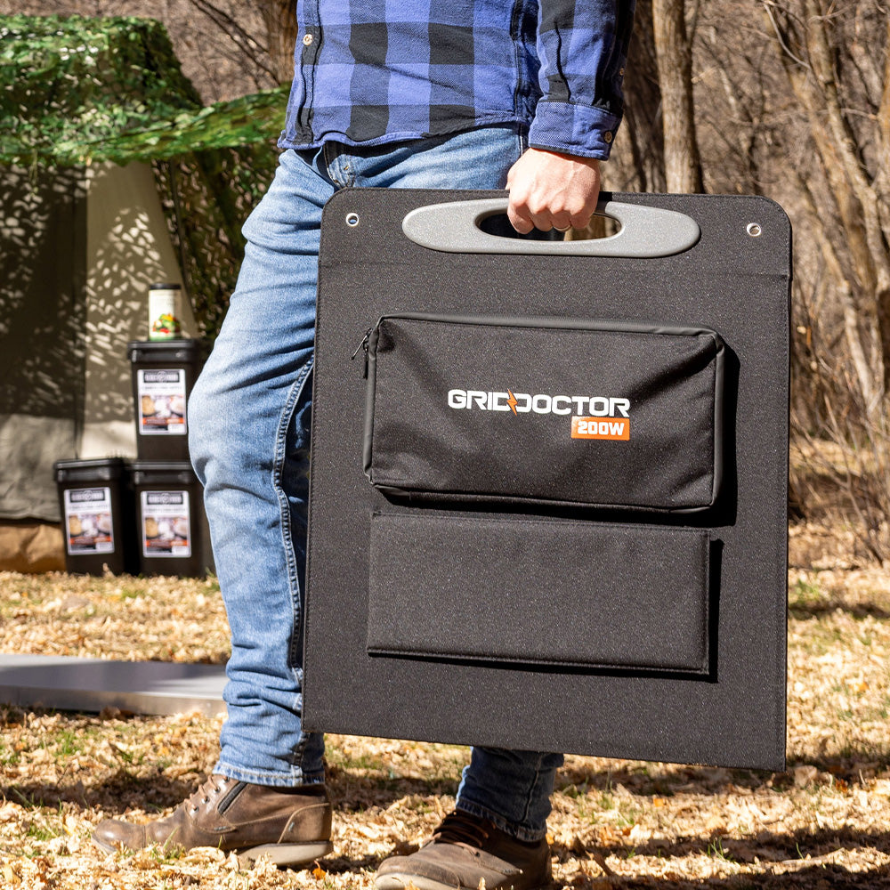 Man confidently carrying the Grid Doctor 200W Solar Panel Kit in its protective case at his side outdoors, highlighting the portability and practicality of the kit for outdoor use.