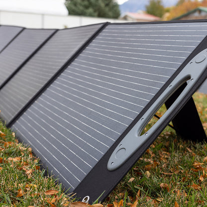 Grid Doctor 200W Solar Panel fully unfolded on autumn grass, capturing sunlight with its high-efficiency cells, ideal for off-grid power in fall conditions.
