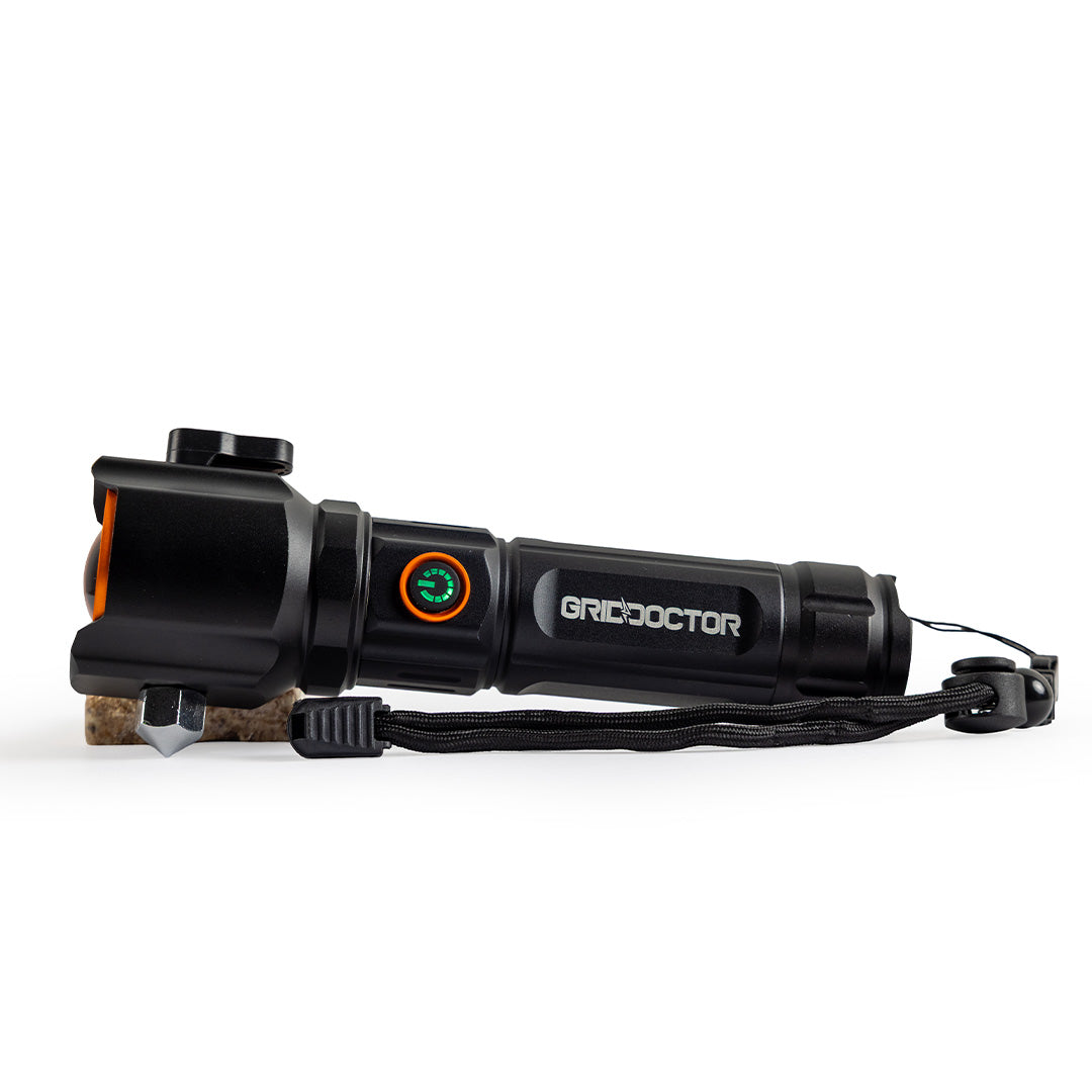 Grid Doctor Survival 1K-LM Flashlight with power button illuminated and lanyard attached