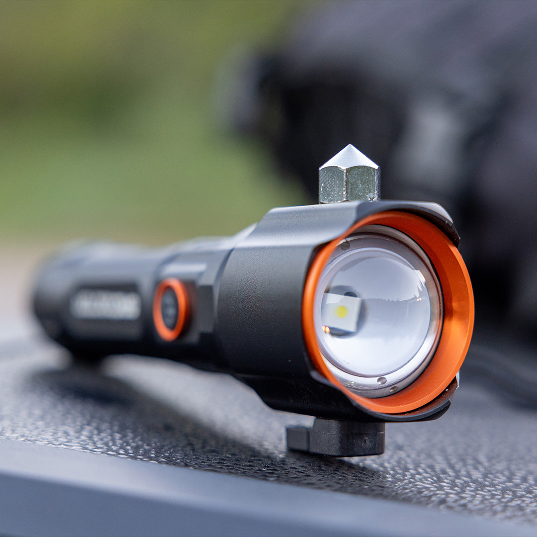 Grid Doctor Survival 1K-LM Flashlight mounted on vehicle dashboard, showing glass breaker tip