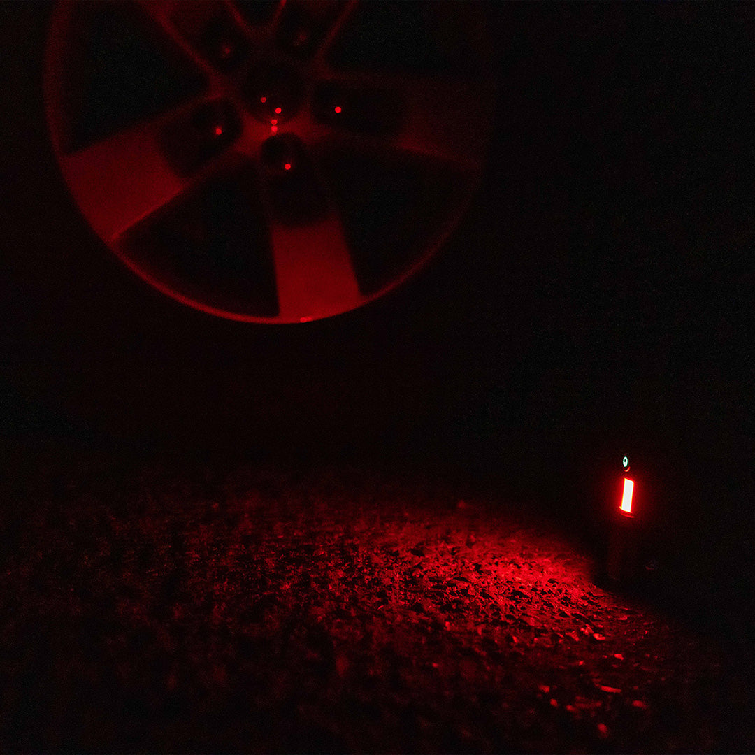 Grid Doctor Survival 1K-LM Flashlight in red emergency warning light mode on pavement
