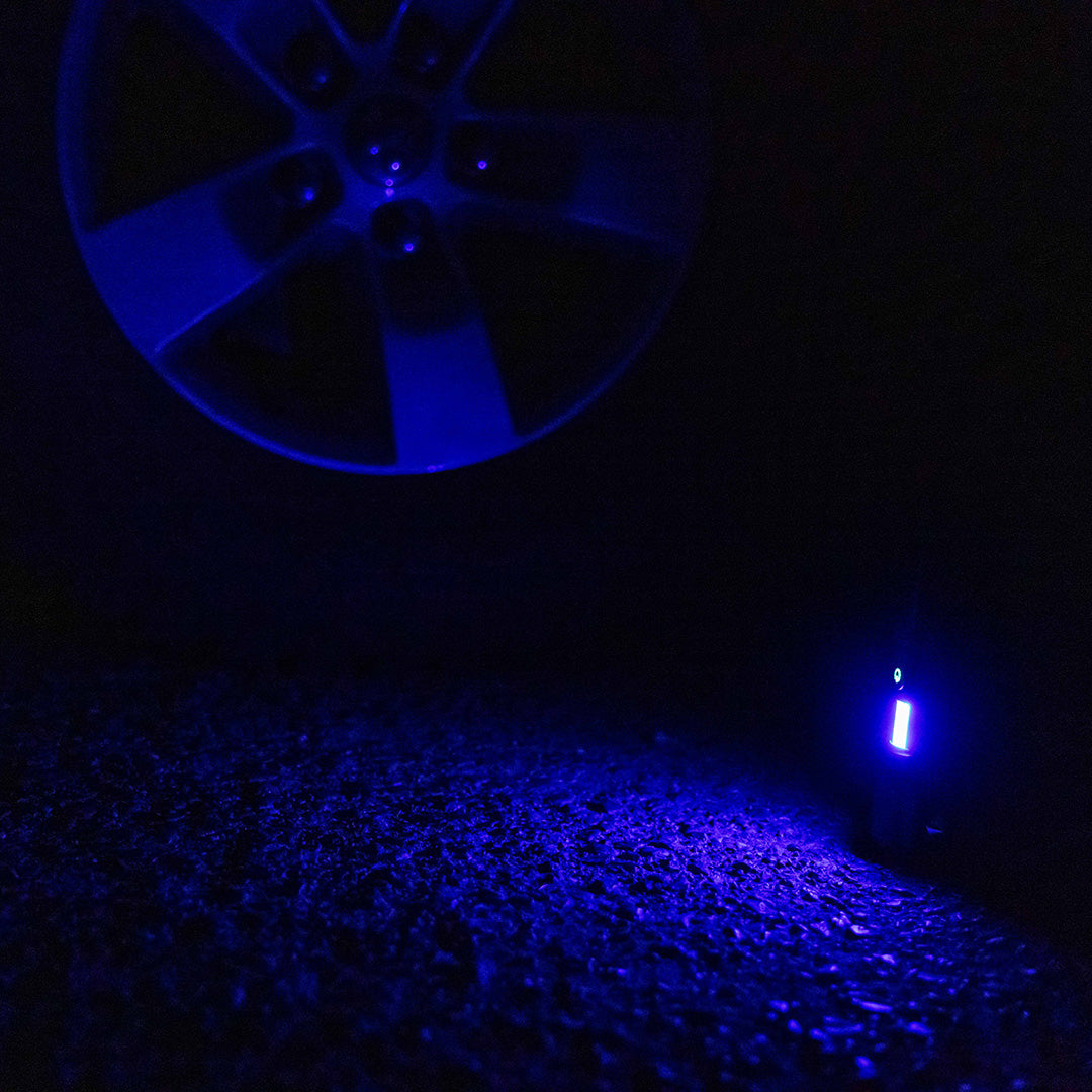 Grid Doctor Survival 1K-LM Flashlight in blue emergency warning light mode on pavement