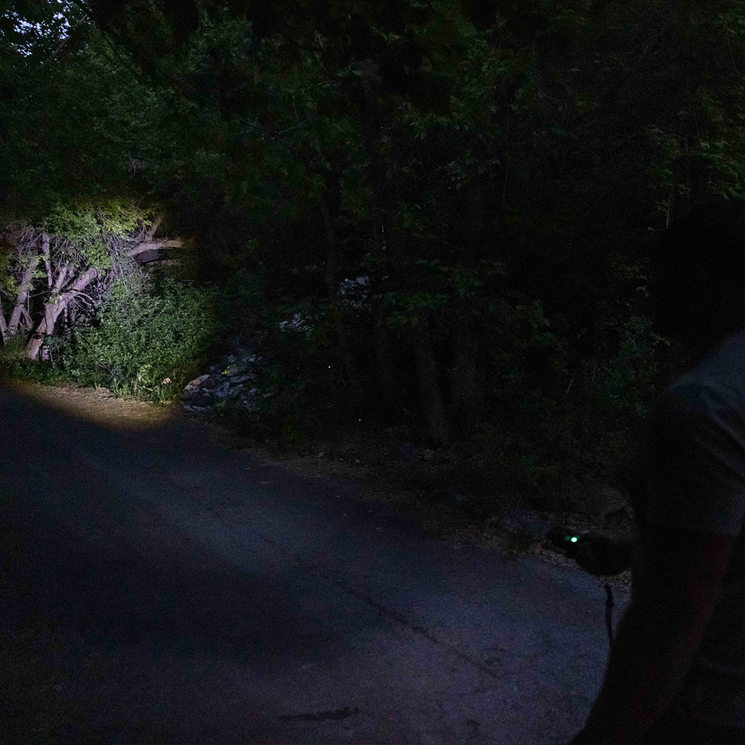 Grid Doctor Survival 1K-LM Flashlight illuminating a dark trail path at night